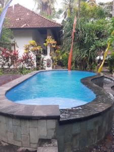 a swimming pool in front of a house at Homestay on the beach in Tejakula