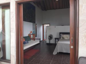 a bedroom with a bed and a couch in a room at Homestay on the beach in Tejakula