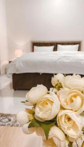 a bouquet of white roses in front of a bed at Peacefull night in Al Madinah