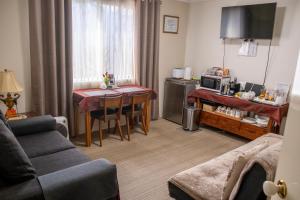 sala de estar con sofá y mesa con microondas en Ascot on Swan Bed & Breakfast en Perth