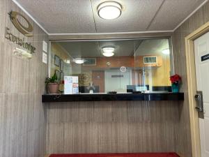 a reflection of a reception desk in a mirror at Econo Lodge in Waite Park
