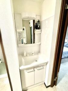 uma casa de banho com um lavatório e um espelho em Shinjuku Waseda House Station 2mins em Tóquio