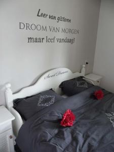 1 dormitorio con 1 cama con un cartel en la pared en Carpe Diem, en Ommen