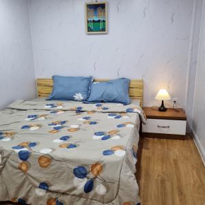 a bedroom with a bed with blue pillows at Homestay nguyên căn Ngọc Vân in Ho Chi Minh City