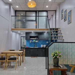 a kitchen and dining room with a table and stairs at Homestay nguyên căn Ngọc Vân in Ho Chi Minh City