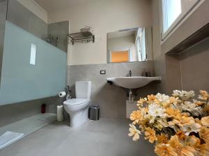 a bathroom with a sink and a toilet and flowers at Cà di Buole A in Mestre