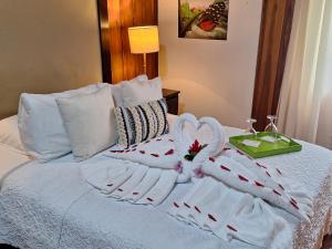 a bed with two towels and a tray on it at Casona Rústica & Bungalow in Fortuna