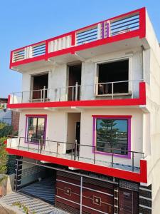 a red and white building with a balcony at Siya home stay in Faizābād