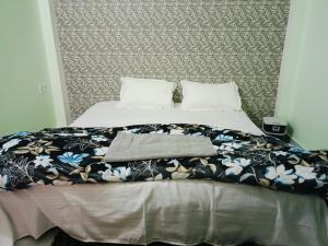 a bed with a black and white blanket on it at Siya home stay in Faizābād