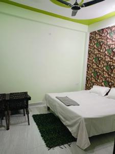 a white bedroom with a bed and a piano at Siya home stay in Faizābād