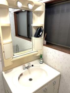 a bathroom with a sink and a mirror at Nikko World Heritage STAY【日光山内】一棟丸貸しの宿 in Nikko