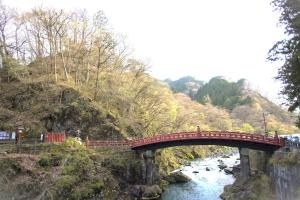 un puente rojo sobre un río en una montaña en Nikko World Heritage STAY【日光山内】一棟丸貸しの宿, en Nikko