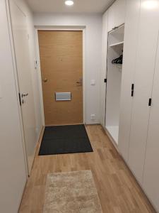 um corredor com uma porta de madeira e um tapete em Upea yksiö ydinkeskustasta. em Lappeenranta