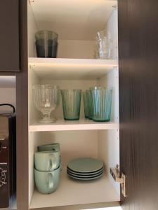a cupboard with dishes and bowls and plates at Upea yksiö ydinkeskustasta. in Lappeenranta
