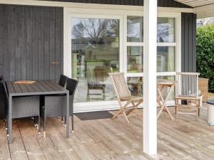 een patio met een tafel en stoelen op een veranda bij 4 person holiday home in Hejls in Hejls