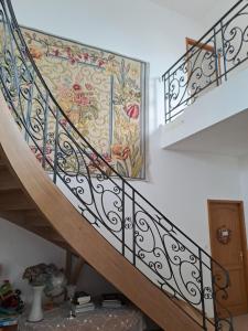 a staircase with a mural of flowers on the wall at chez céline in Sens-de-Bretagne
