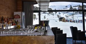 a bar with wine glasses and a view of a ski slope at Grand Hotel Caviahue in Caviahue
