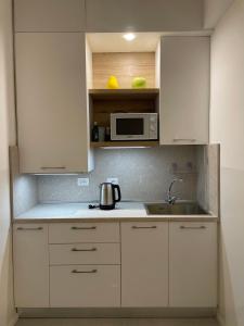 a kitchen with white cabinets and a sink and a microwave at Cà di Buole 8B in Mestre