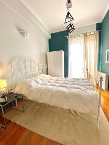een slaapkamer met een wit bed en een blauwe muur bij Sacred Way Modern apartment in Athene