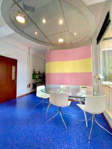 een kamer met een tafel en stoelen en een kleurrijke muur bij Sacred Way Modern apartment in Athene