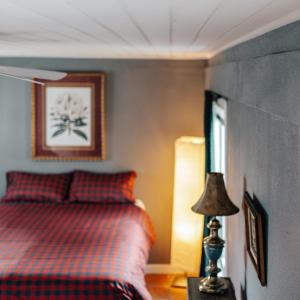 a bedroom with a bed and a lamp on a table at 2 BR 3 BD Historical Cottage at UT and Austin Downtown in Austin