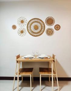 a wooden table with chairs and plates on a wall at "Zen Spot" Saekyung Condo Unit in Lapu-Lapu City in Lapu Lapu City