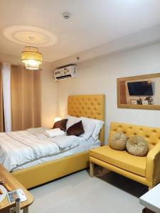 a bedroom with a bed and a yellow chair at "Zen Spot" Saekyung Condo Unit in Lapu-Lapu City in Lapu Lapu City