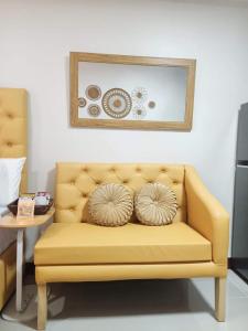 a yellow couch with two pillows on it at "Zen Spot" Saekyung Condo Unit in Lapu-Lapu City in Lapu Lapu City