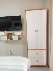 a bedroom with a white cabinet and a tv at "Zen Spot" Saekyung Condo Unit in Lapu-Lapu City in Lapu Lapu City
