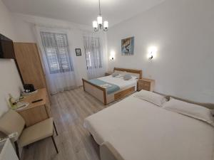 1 Schlafzimmer mit 2 Betten, einem Schreibtisch und einem Stuhl in der Unterkunft Casa Bella in Sibiu