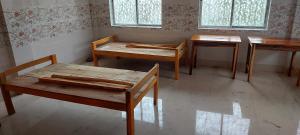 Habitación con 2 mesas, mesa y sillas en MAA PG, en Silchar
