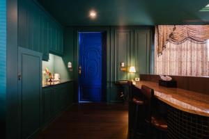 a blue door in a green room with a bar at The Sea-Cret Garden Hua Hin in Hua Hin