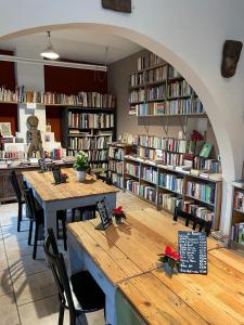 a library with several tables and chairs and bookshelves at La Reduiste in Redu