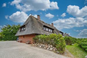 a thatched house with a thatched roof at Wattblick in Braderup