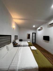 a large room with two beds and a tv at S8 Boutique Hotel near KLIA 1 & KLIA 2 in Sepang