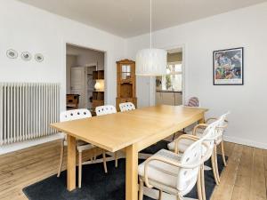 una sala da pranzo con tavolo in legno e sedie bianche di Holiday home Holeby a Holeby