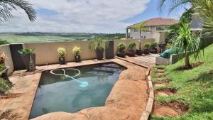a swimming pool in front of a house at 54 Asteria Ave, Larnaco Estate in Kingsburgh