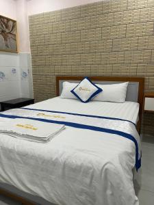 Ðông HòaにあるHương Thiên Phú Hotelの白と青のシーツと枕が備わる大きな白いベッド