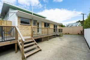 une maison avec une terrasse couverte et un escalier dans l'établissement Riverside Retreat, à Whangarei