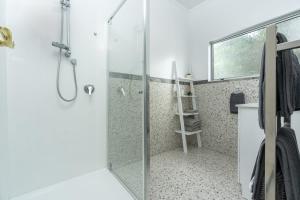 a bathroom with a shower with a glass door at Riverside Retreat in Whangarei