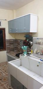una cucina con mobili bianchi e un piano di lavoro di Homestay Trisakti 2 Syariah a Diyeng