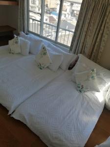 東京にあるTokyo downtown芍藥莊の大きな白いベッド(枕付)、窓が備わります。