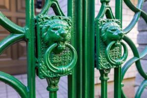 a green metal door with two lions on it at Premier suite Nishiazabu Roppongi front in Tokyo