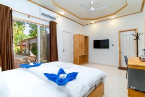 Tropico villa في أوكولهاس: غرفة نوم عليها سرير مع وردة زرقاء