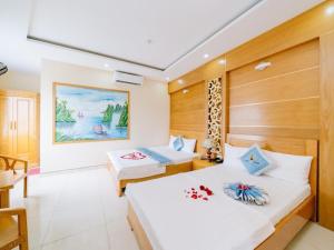 a bedroom with two beds in a room at Lang Chai Hotel - Travel Agency in Cat Ba