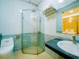 a bathroom with a glass shower and a toilet and a sink at Lang Chai Hotel - Travel Agency in Cat Ba