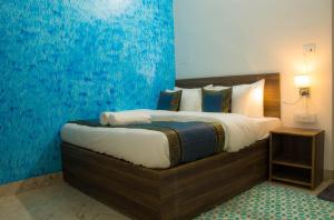 1 dormitorio con 1 cama grande y pared azul en Live Free Hostel Varanasi en Varanasi