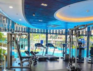 einen Fitnessraum mit blauen Decken und einem Pool in der Unterkunft Modern Spacious 1BR with Free Amazing Pool, Gym and Garden By SYM B1209 in Phnom Penh