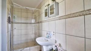 ein weißes Badezimmer mit einem Waschbecken und einem Spiegel in der Unterkunft 54 on Asteria 2 in Amanzimtoti