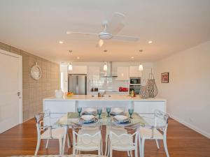 a kitchen and dining room with a table and chairs at Tairua Marina Villa in Tairua